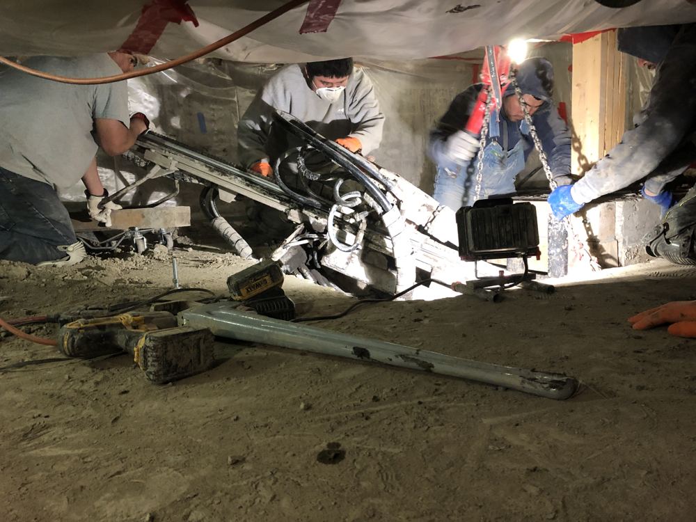 Crew drilling in a tight residential crawl space